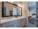 Elegant bathroom featuring double sinks, granite counters, tile flooring, and a large framed mirror at 36298 N Crucillo Dr, Queen Creek, AZ 85140