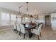 Dining area with tile flooring, a wooden dining table, and lovely overhead chandelier lighting fixtures at 36298 N Crucillo Dr, Queen Creek, AZ 85140