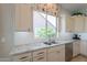Kitchen displays white cabinets, granite countertops, stainless steel appliances, and large window at 36298 N Crucillo Dr, Queen Creek, AZ 85140
