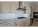 Modern kitchen features stainless steel hood, white cabinets, and granite countertops at 36298 N Crucillo Dr, Queen Creek, AZ 85140