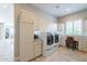 Bright laundry room includes modern washer and dryer, storage cabinets, and large countertops, ideal for organization at 36298 N Crucillo Dr, Queen Creek, AZ 85140