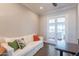 Cozy living room with a white sofa, wood floors, and doors leading to an outdoor view at 36298 N Crucillo Dr, Queen Creek, AZ 85140