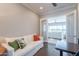 Cozy living room with a white sofa, wood floors, and doors leading to an outdoor view at 36298 N Crucillo Dr, Queen Creek, AZ 85140