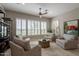 Bright living room with tile floors features a ceiling fan, recessed lights, and multiple seating areas at 36298 N Crucillo Dr, Queen Creek, AZ 85140