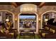 Elegant living room with stone accents, arched doorways, and views of the lush golf course and mountain at 36298 N Crucillo Dr, Queen Creek, AZ 85140