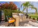 Inviting outdoor kitchen with stainless steel grill, verdant landscaping, and beautiful golf course view at 36298 N Crucillo Dr, Queen Creek, AZ 85140