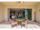 Covered patio with dining set overlooks the bright living room, lush golf course views beyond at 36298 N Crucillo Dr, Queen Creek, AZ 85140
