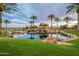 Scenic pond with cascading waterfall, lush landscaping, palm trees, and golf course in the background at 36298 N Crucillo Dr, Queen Creek, AZ 85140