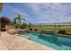 Beautiful pool and spa with a stone waterfall feature overlook a golf course with an outdoor kitchen area at 36298 N Crucillo Dr, Queen Creek, AZ 85140