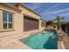 Backyard pool with baja shelf, outdoor kitchen, and travertine decking create a luxurious outdoor living space at 36298 N Crucillo Dr, Queen Creek, AZ 85140