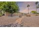 Backyard view with stone pathway, mature trees, neutral landscaping, and a glimpse of the pool at 3823 E Poinsettia Dr, Phoenix, AZ 85028
