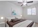 Bright bedroom featuring a ceiling fan, a large window, and a comfortable bed with neutral bedding at 3823 E Poinsettia Dr, Phoenix, AZ 85028