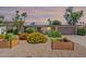 Charming home with desert landscaping and colorful flowering bushes in planter boxes under a colorful sky at 3823 E Poinsettia Dr, Phoenix, AZ 85028