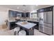 Modern kitchen features stainless appliances, granite counters, and a large center island with barstool seating at 3823 E Poinsettia Dr, Phoenix, AZ 85028