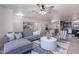 Bright and airy living room with a gray sectional, ceiling fan, adjacent dining area, and decorative rug at 3823 E Poinsettia Dr, Phoenix, AZ 85028