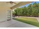Covered back patio overlooking a grass yard, rock landscaping, and lush green privacy trees at 3872 E Jude Ln, Gilbert, AZ 85298