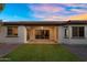 Evening view of patio and backyard featuring artificial turf, gravel, and mature trees at 3872 E Jude Ln, Gilbert, AZ 85298