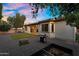 Dusk view of backyard with covered patio, landscaping, artificial turf, and outdoor grill at 3872 E Jude Ln, Gilbert, AZ 85298