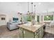 Kitchen island featuring granite countertop, sink, green cabinetry, and open view to the living room at 3872 E Jude Ln, Gilbert, AZ 85298