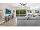 Spacious living room with a ceiling fan, a gray sectional, and sliding glass doors to the backyard at 3872 E Jude Ln, Gilbert, AZ 85298