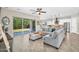 Open concept living room with a gray sectional, sliding doors to the backyard, and a modern kitchen view at 3872 E Jude Ln, Gilbert, AZ 85298