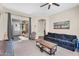 Cozy living room with a dark blue sofa, a wooden coffee table, and sliding door to the patio at 3872 E Jude Ln, Gilbert, AZ 85298