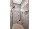 Walk-in shower featuring stylish tile work, built-in shelving, and a window letting in natural light at 3872 E Jude Ln, Gilbert, AZ 85298