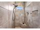 Walk-in shower featuring stylish tile work, built-in shelving, and a window letting in natural light at 3872 E Jude Ln, Gilbert, AZ 85298