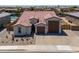 Aerial view of a single-Gathering home with desert landscaping, a three-car garage and a tiled roof at 40725 W Hall Dr, Maricopa, AZ 85138