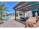 Spacious backyard patio with a pergola, ideal for outdoor gatherings by the pool at 40725 W Hall Dr, Maricopa, AZ 85138