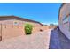 Paver backyard with brick walls, desert landscaping, and a cozy bench for outdoor enjoyment at 40725 W Hall Dr, Maricopa, AZ 85138