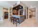 Inviting custom bar with seating, beautiful wood accents, and stylish lighting at 40725 W Hall Dr, Maricopa, AZ 85138