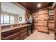 Rustic bar area, complete with wood accents, a beverage fridge, and views to outdoor pool at 40725 W Hall Dr, Maricopa, AZ 85138