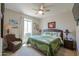 Inviting bedroom with tropical bedding, rattan chair, and decorative lamps at 40725 W Hall Dr, Maricopa, AZ 85138
