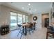 Bright dining area with modern light fixture and access to an outdoor pool and patio at 40725 W Hall Dr, Maricopa, AZ 85138