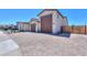 Spacious home exterior with a three-car garage and a paver driveway, nestled in a residential area at 40725 W Hall Dr, Maricopa, AZ 85138