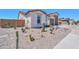 Landscaped front yard featuring desert plants and rock ground cover, complementing the home's exterior at 40725 W Hall Dr, Maricopa, AZ 85138