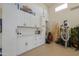 Well-organized garage with cabinets, workbench, and epoxy flooring at 40725 W Hall Dr, Maricopa, AZ 85138