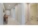 Inviting hallway with tiled floors leading to the front door and half bath at 40725 W Hall Dr, Maricopa, AZ 85138