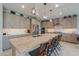 Spacious kitchen with an oversized granite island, stainless appliances, and modern lighting at 40725 W Hall Dr, Maricopa, AZ 85138