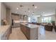 Stylish kitchen with large island, stainless steel appliances, and open access to living room at 40725 W Hall Dr, Maricopa, AZ 85138