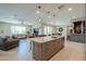 Spacious open floor plan showcasing kitchen island with granite countertops, sink, and seamless flow into the living room at 40725 W Hall Dr, Maricopa, AZ 85138
