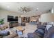Open-concept living room with a ceiling fan and easy access to the kitchen and bar at 40725 W Hall Dr, Maricopa, AZ 85138