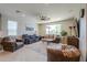Inviting living room with large windows, comfortable sofas, and neutral-toned decor at 40725 W Hall Dr, Maricopa, AZ 85138