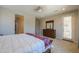 Well-lit main bedroom featuring a cozy bed, dresser, and access to the backyard at 40725 W Hall Dr, Maricopa, AZ 85138