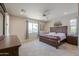 Comfortable main bedroom with large windows, a ceiling fan, and carpeted floors at 40725 W Hall Dr, Maricopa, AZ 85138