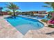 Gorgeous waterfront pool with travertine tile surround and lush tropical landscaping at 40725 W Hall Dr, Maricopa, AZ 85138