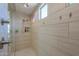 Spacious tiled shower with multiple shower heads and built-in shelves at 40725 W Hall Dr, Maricopa, AZ 85138