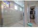 Modern tiled shower with glass door and decorative stained glass window at 40725 W Hall Dr, Maricopa, AZ 85138