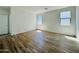 Spacious bedroom with wood-look flooring, two large windows, and a door leading to a private bathroom at 46819 W Cansados Rd, Maricopa, AZ 85139